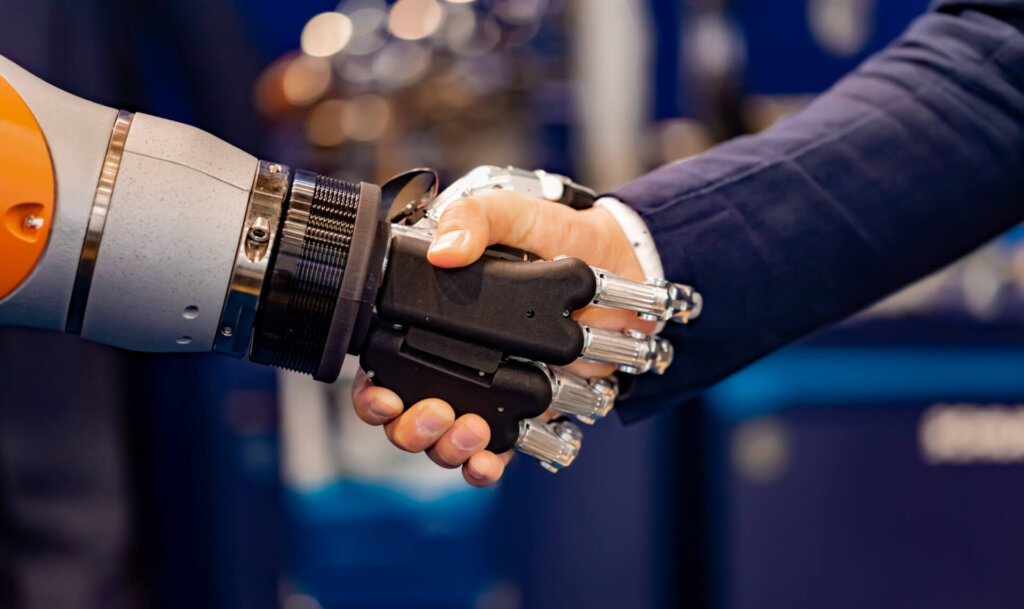 Hand of a businessman shaking hands with a Android robot.